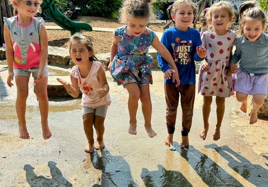 six girls on playground jumping