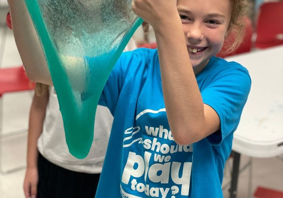 Kid holding slime and smiling