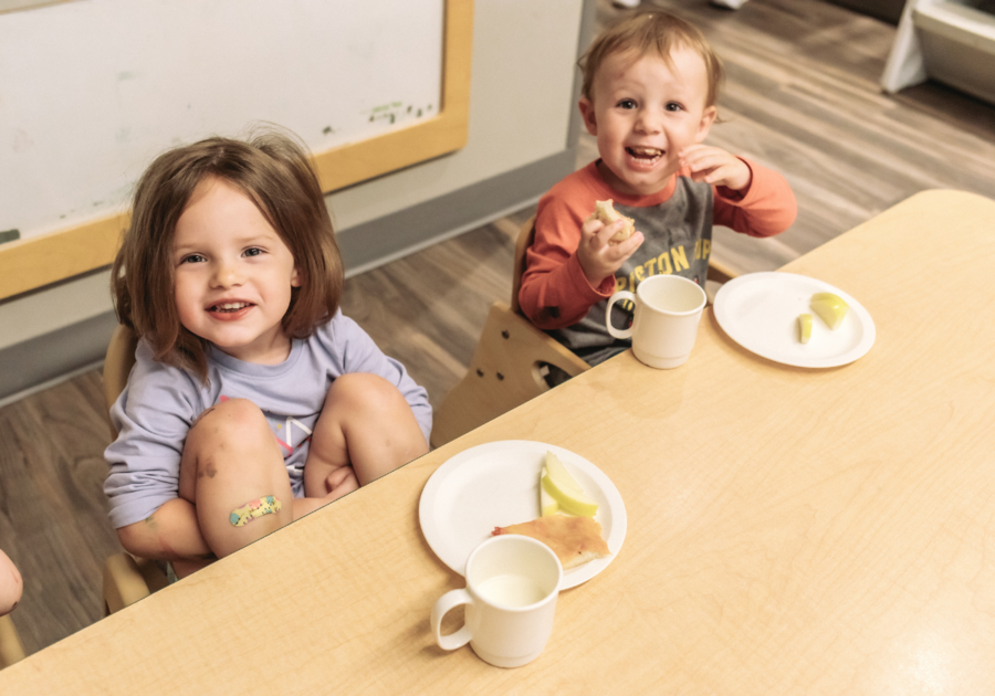 two toddlers eating lunch