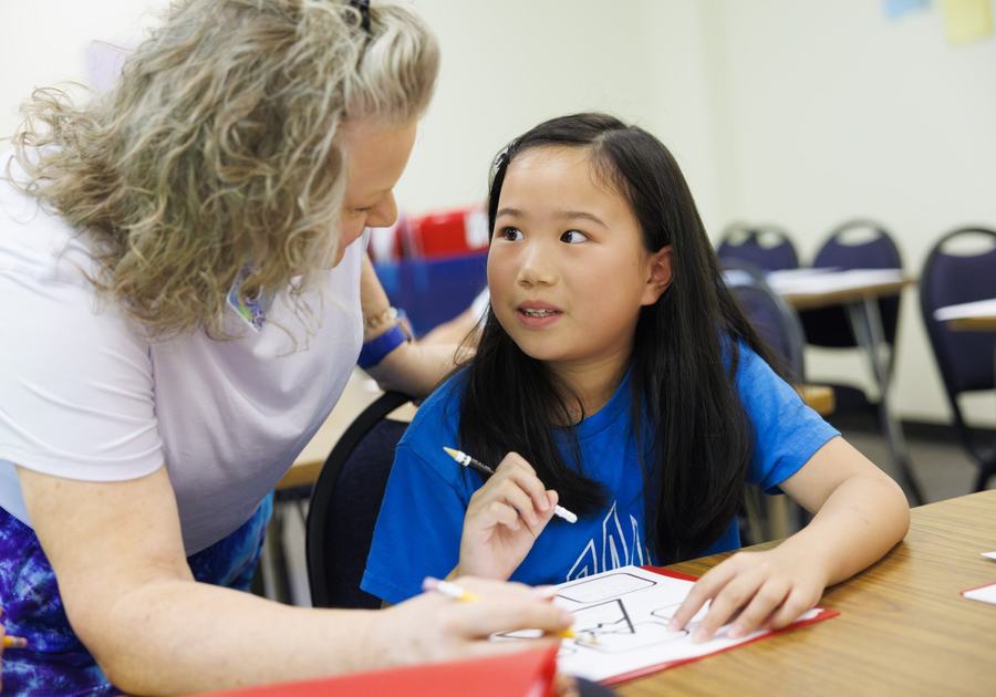 Kid and teacher writing