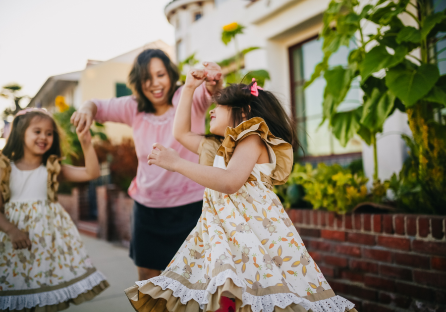 Mother and daughters dancing on the street.