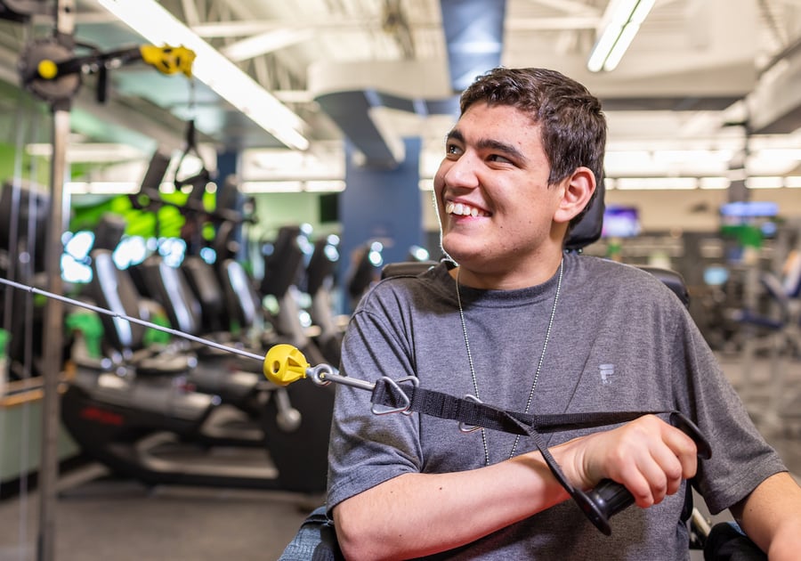 young man in a wheelchair using the equipment in the weight room at the parker recreation center