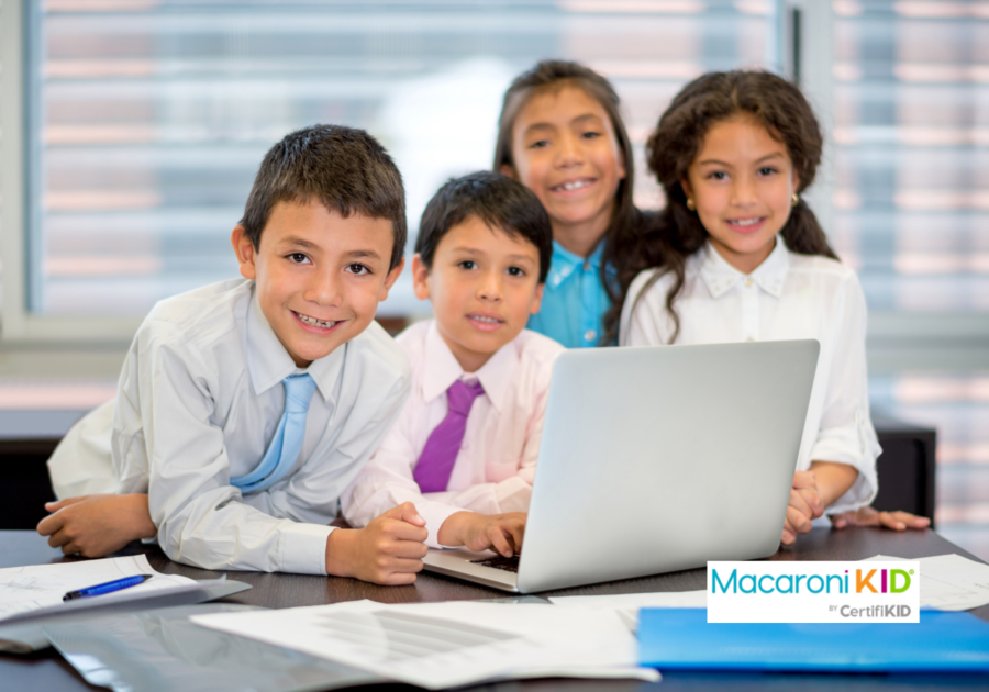 4 kids in business attire by computer in office