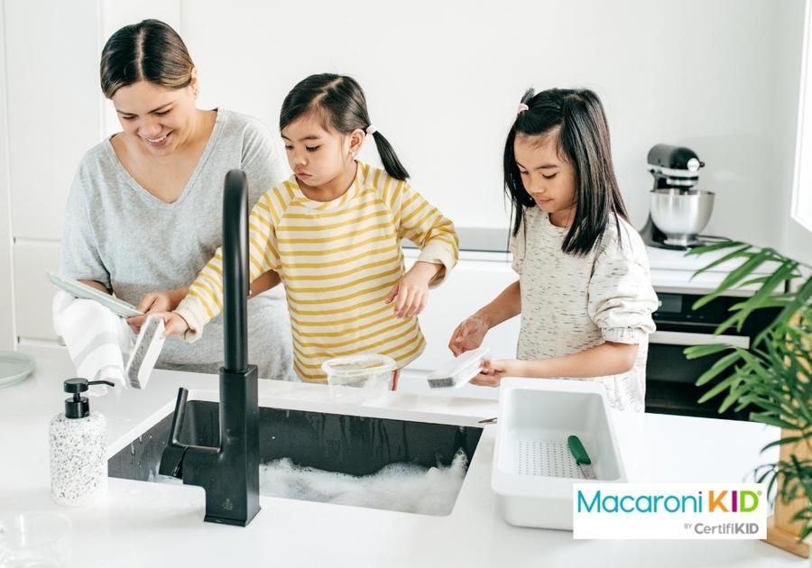 Two girls helping mom with dishes