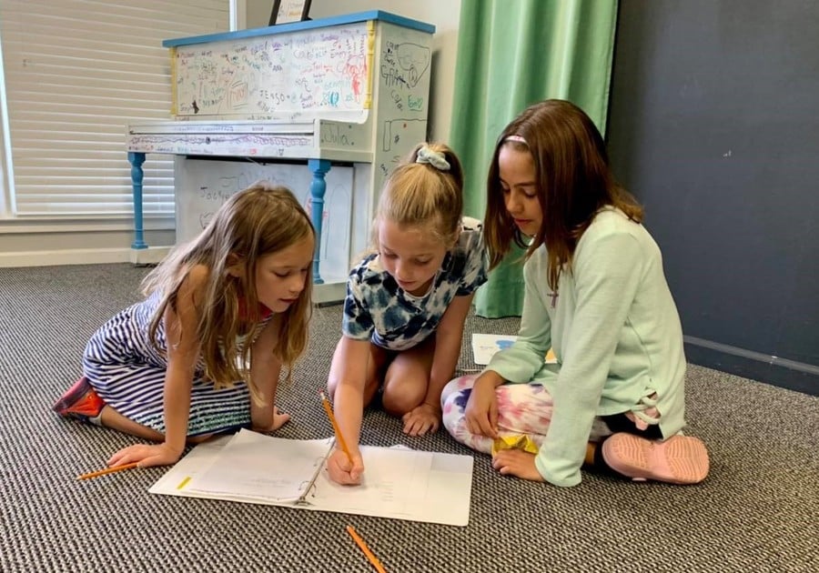 Photo of female campers working on music project