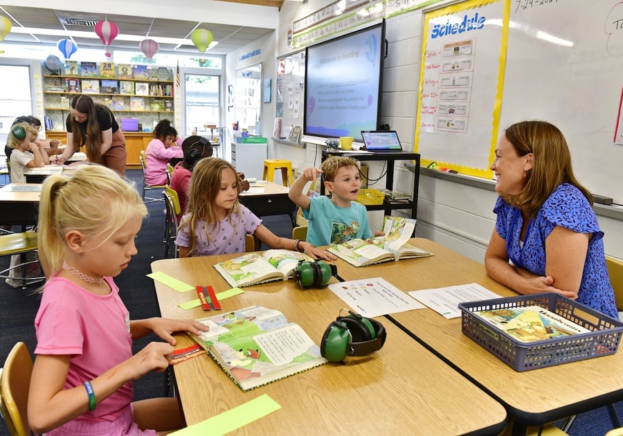 students and teacher sitting at desks