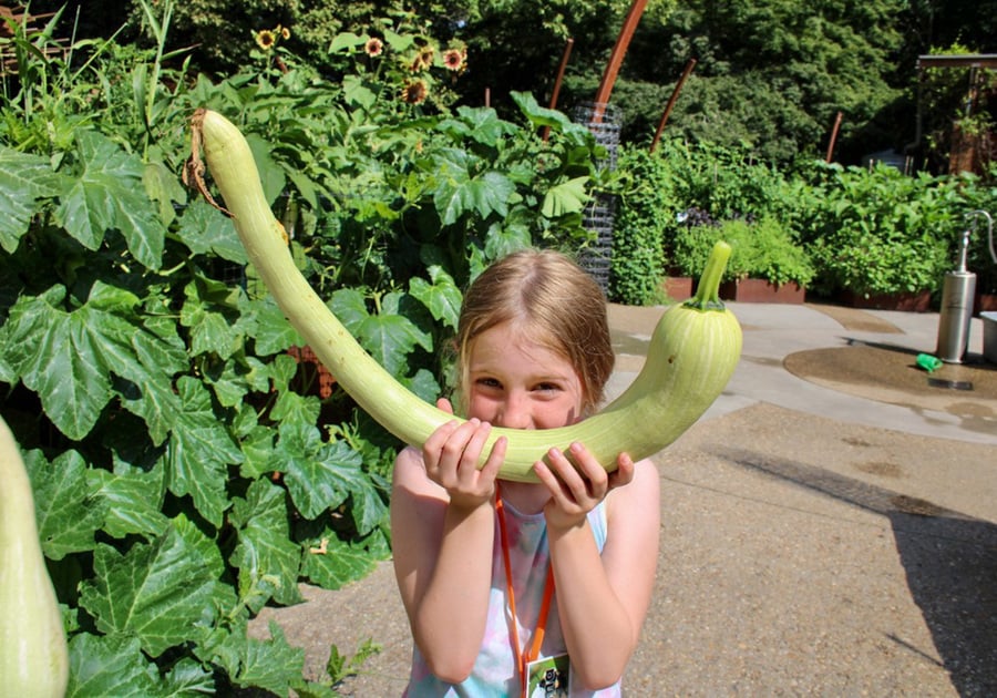 photo of female camper holding large squash