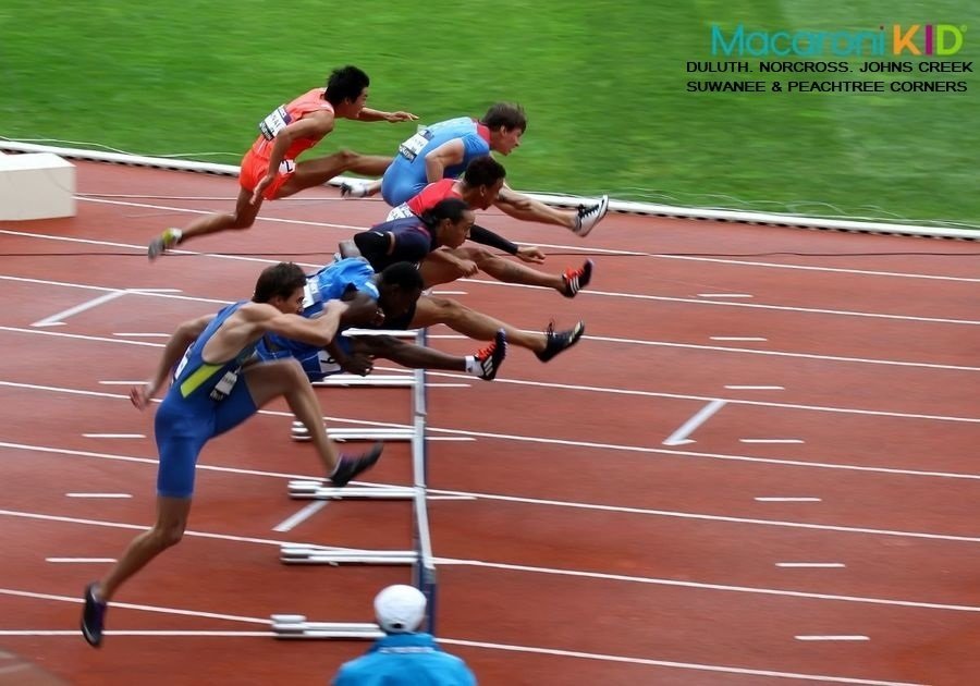Athletes jumping hurdles
