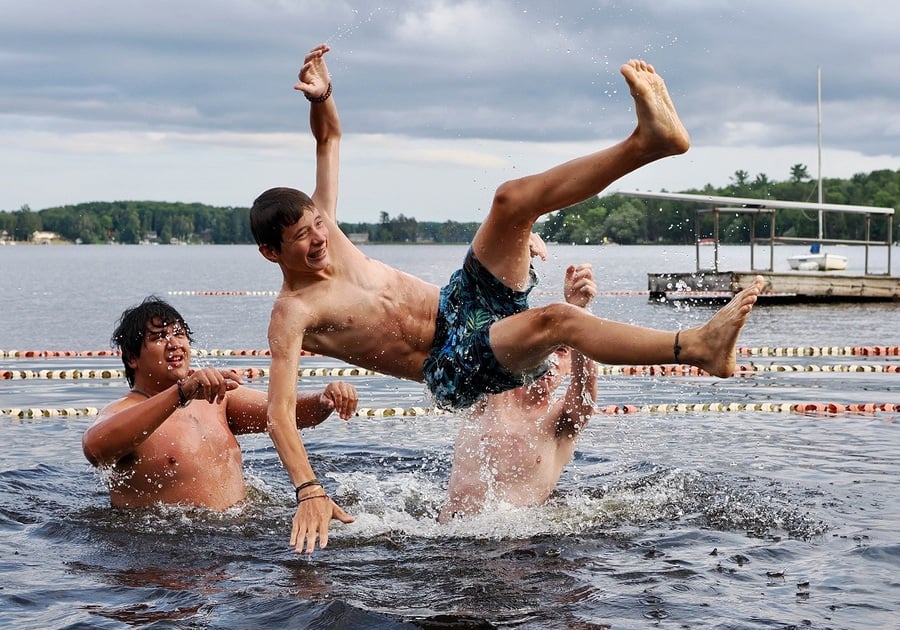 three teen boys in lake