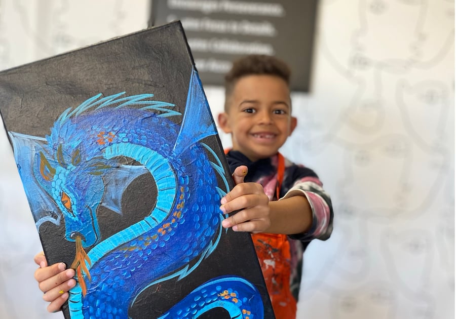 boy showing off his awesome painting of a blue dragon