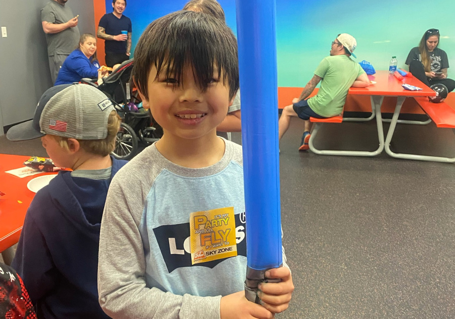 Boy holding a toy at a birthday party at Sky Zone Indoor Trampoline Park