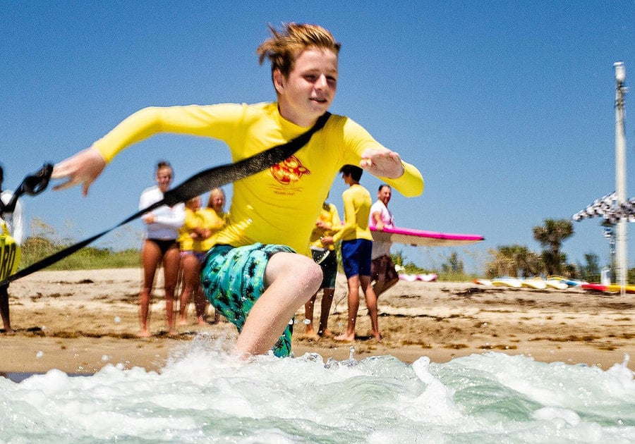 Treasure Coast Junior Lifeguards Boy running into ocean