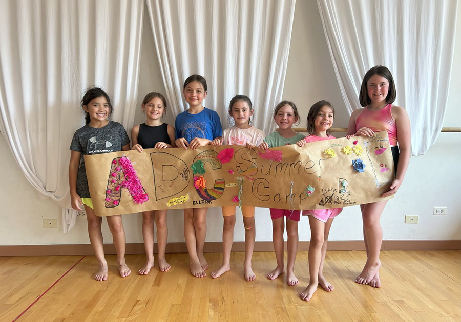 seven young girls holding a banner