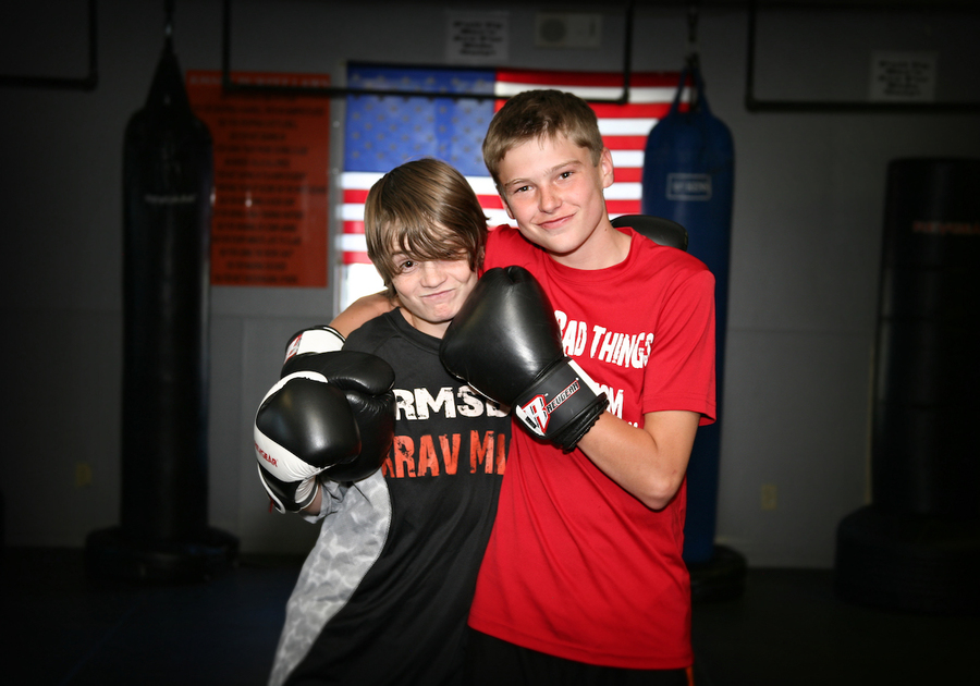 two teen boys wearing boxing gloves and posing together