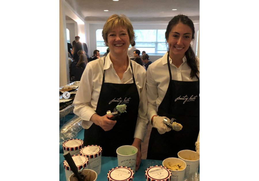 two women in aprons scooping ice cream