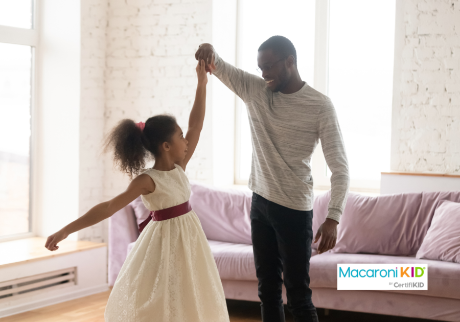 dad dancing with little daughter in living room