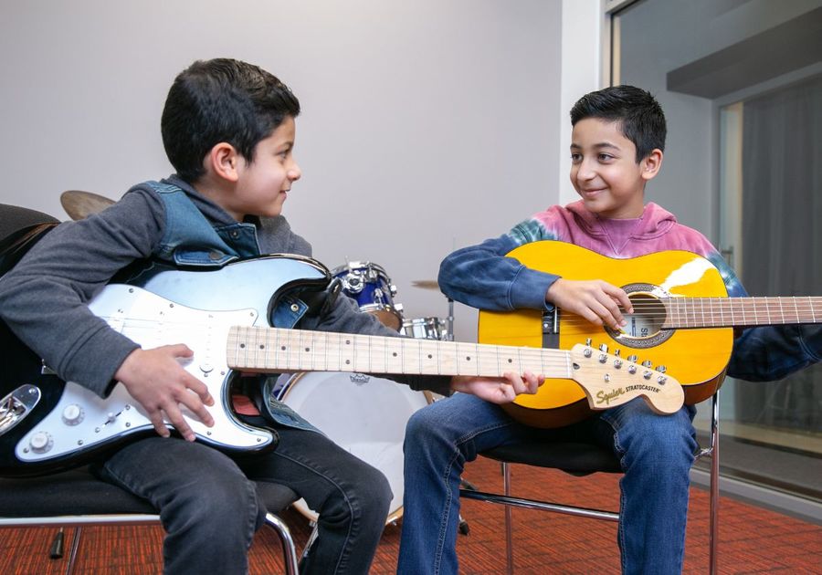 two boys playing guitar