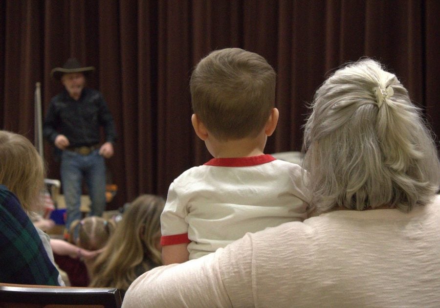 Young child and their adult sitting in the audience watching a family-friendly performance at the Lone Tree Arts Center
