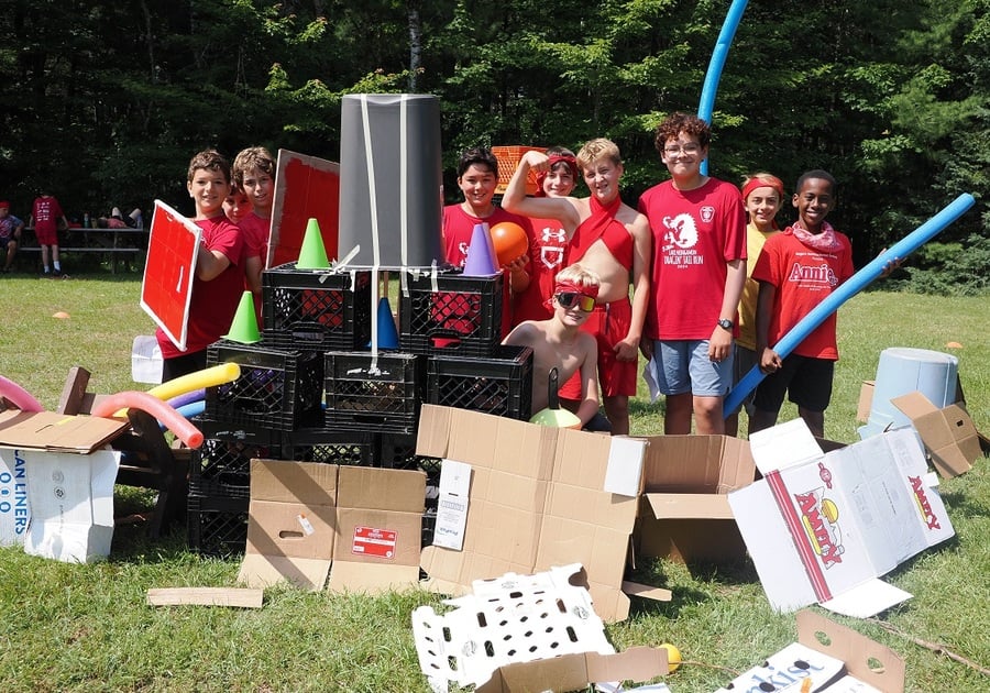 teen campers behind a cardboard fort