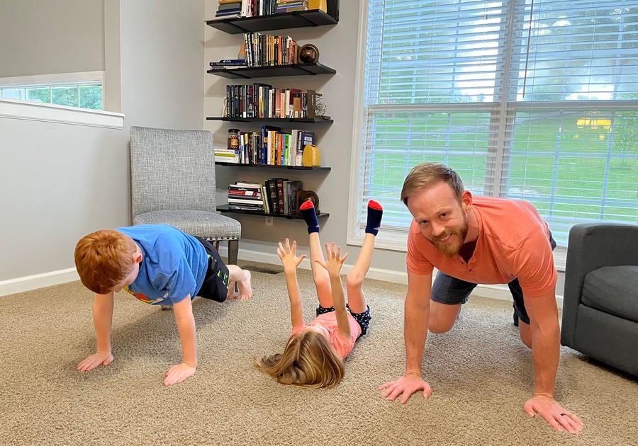 Dad and kids doing yoga in the living room