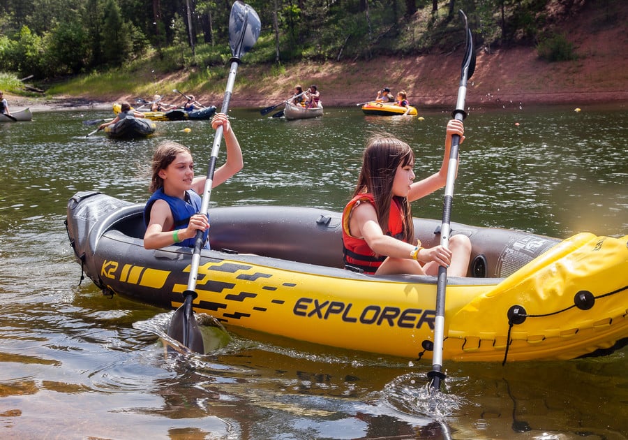 two girls paddling in an inflatable canoe at Girl Scouts of Colorado summer camp