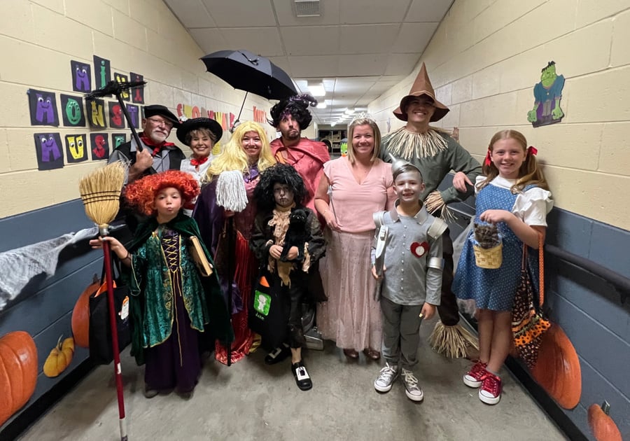 children and adults dressed in Halloween costumes