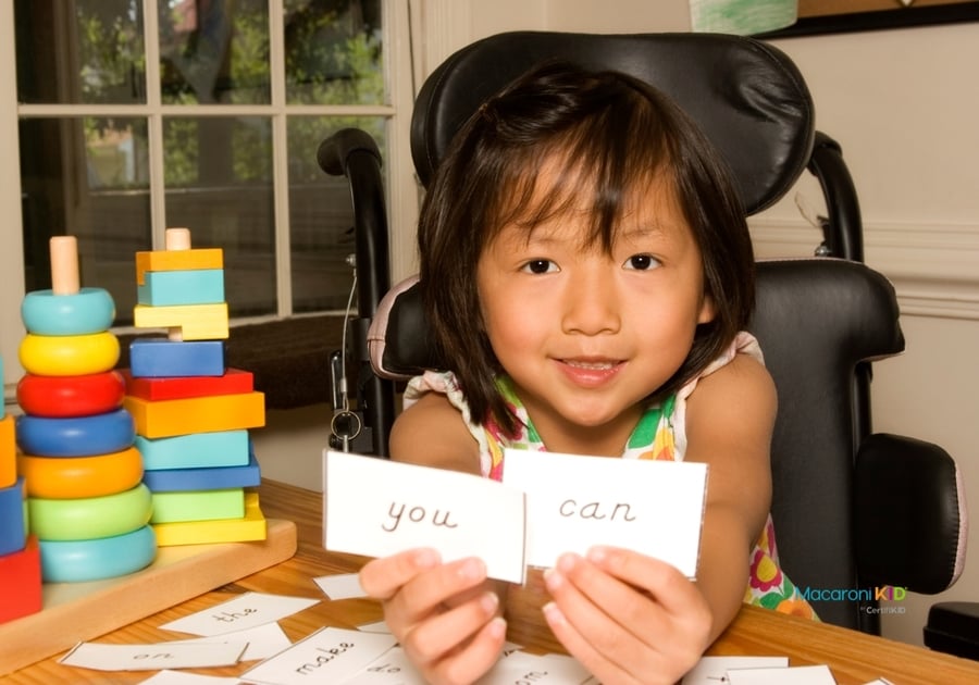 Girl in wheelchair holding sight words