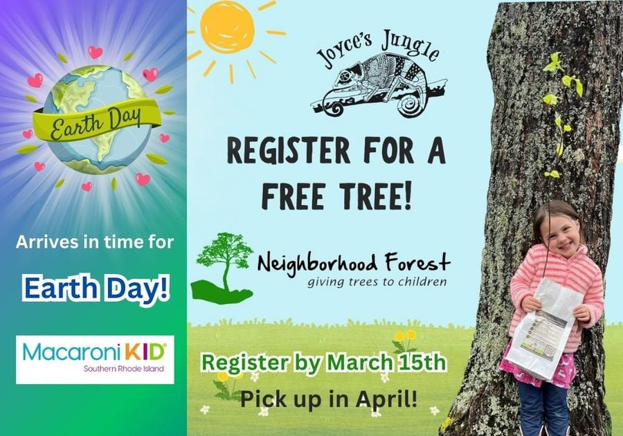 Child smiles while holding a sapling while leaning up against a tree