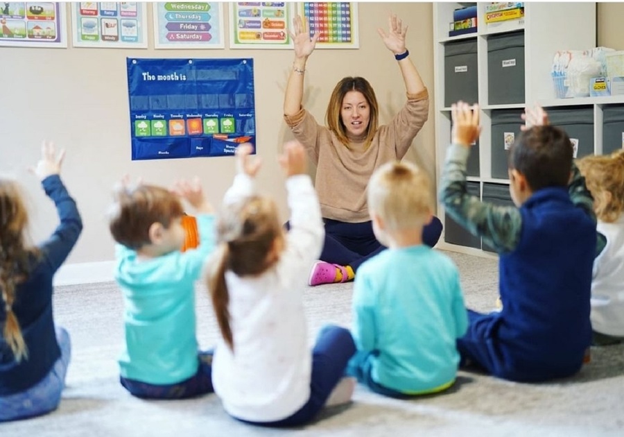 teacher leading kids to raise hands