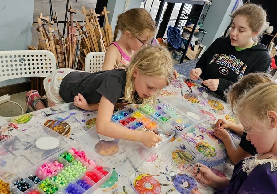 female campers working on colorful bead project