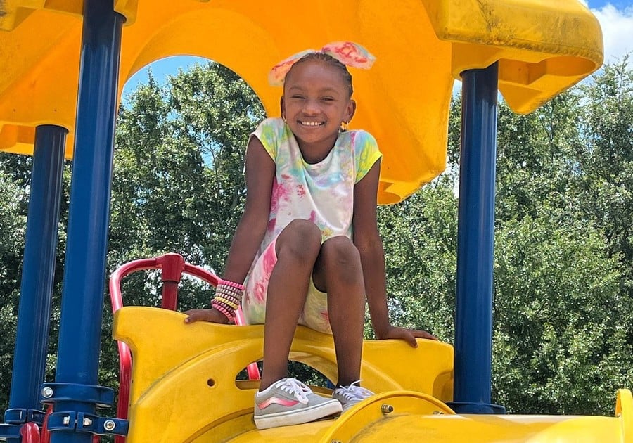 photo of young girl sitting on outdoor playground