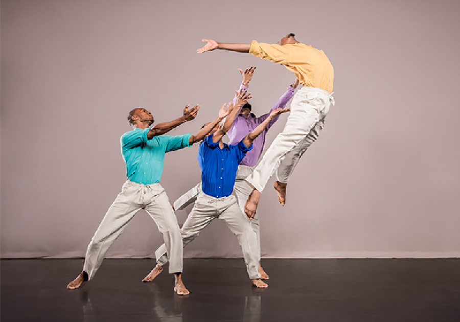 3 men tossing another man in the air during a dance performance