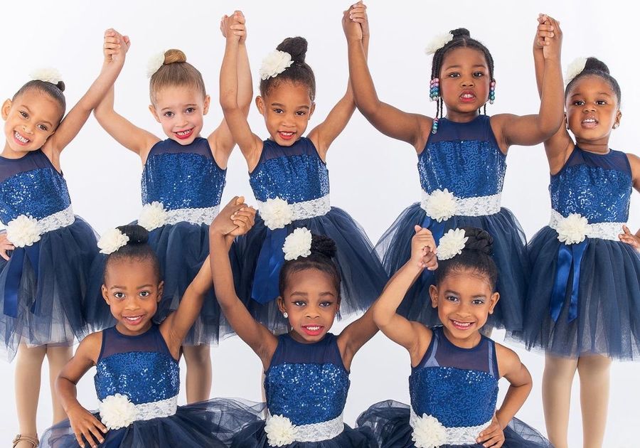 Young Girls in Blue Ballerina costumes holding hands