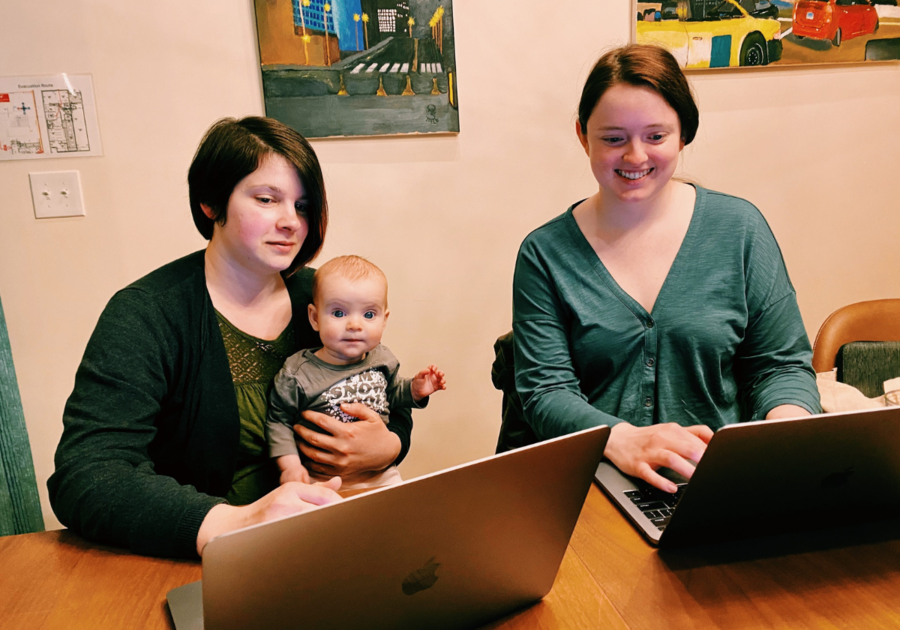 two moms with a baby working on laptops
