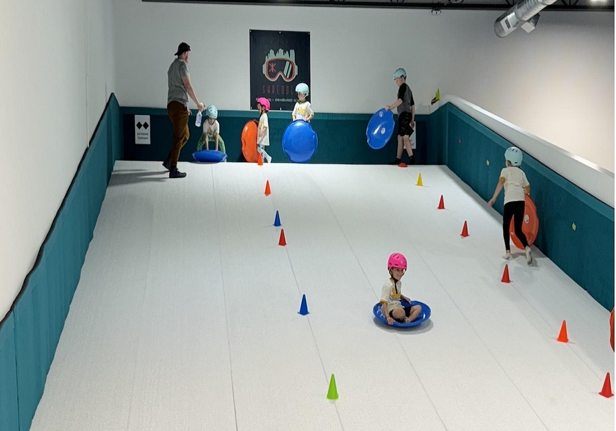 kids sledding down indoor hill