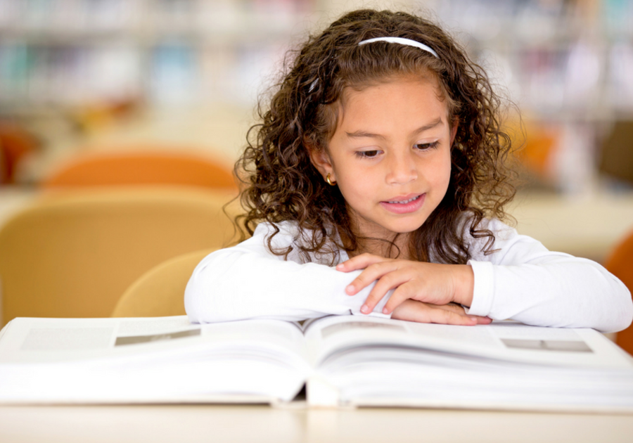 child at desk reading school book