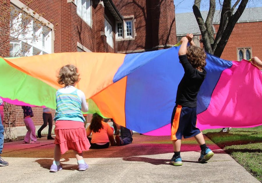 kids playing with rainbow parachute