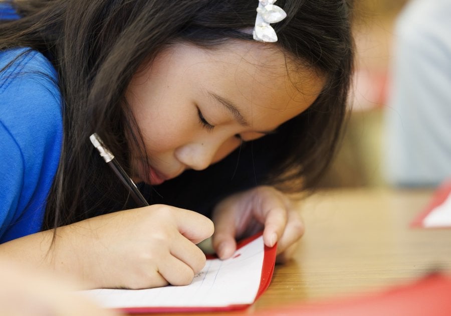 Child writing with a pencil