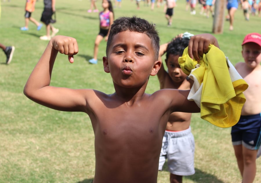 photo of young boy showing arm muscles for photo