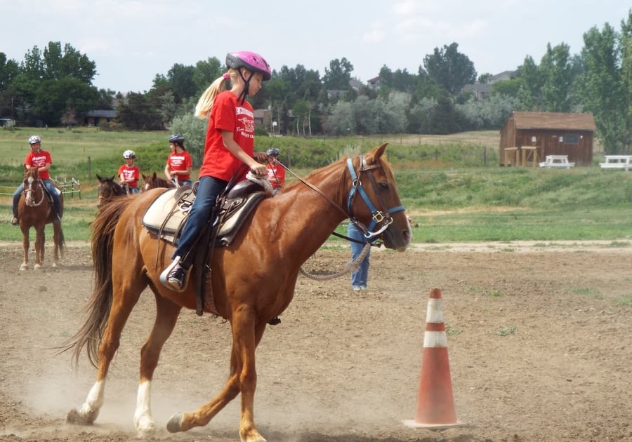 chil on horseback practicing arena obtacles at Big Horn Stables summer camp