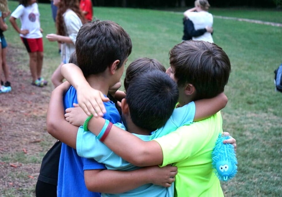 photo of young male campers hugging