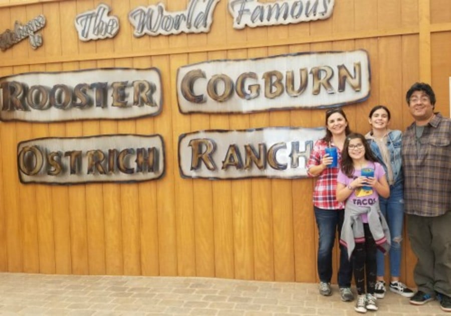 Family in front of sign at Rooster Cogburn Ostrich Ranch