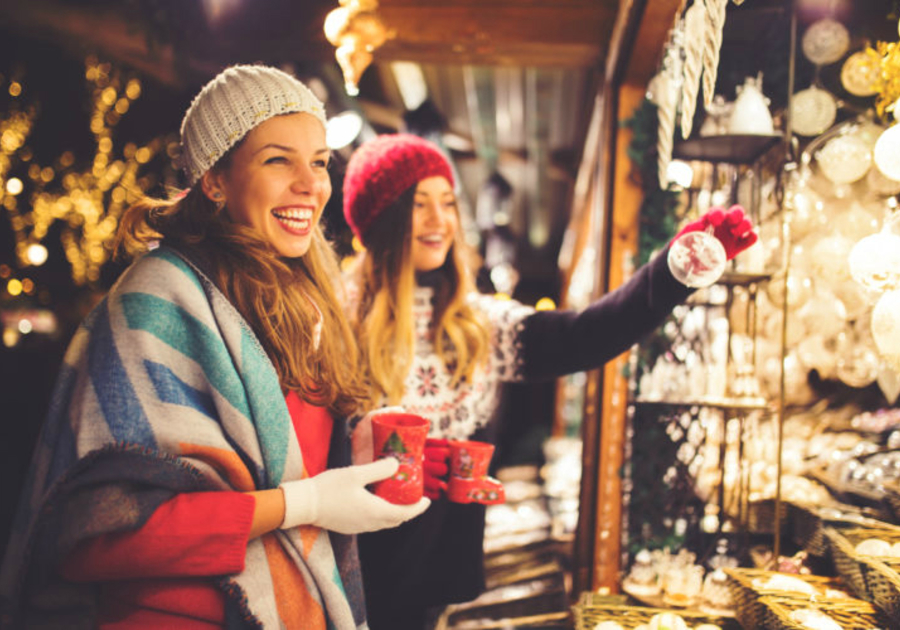 two women shopping outside at holiday market booth