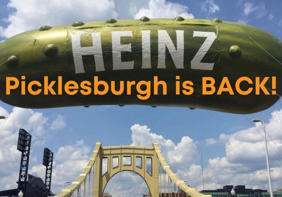Giant green, inflatable Heinz pickle over a yellow Pittsburgh bridge with the words Picklesburgh is BACK! in orange as an overlay