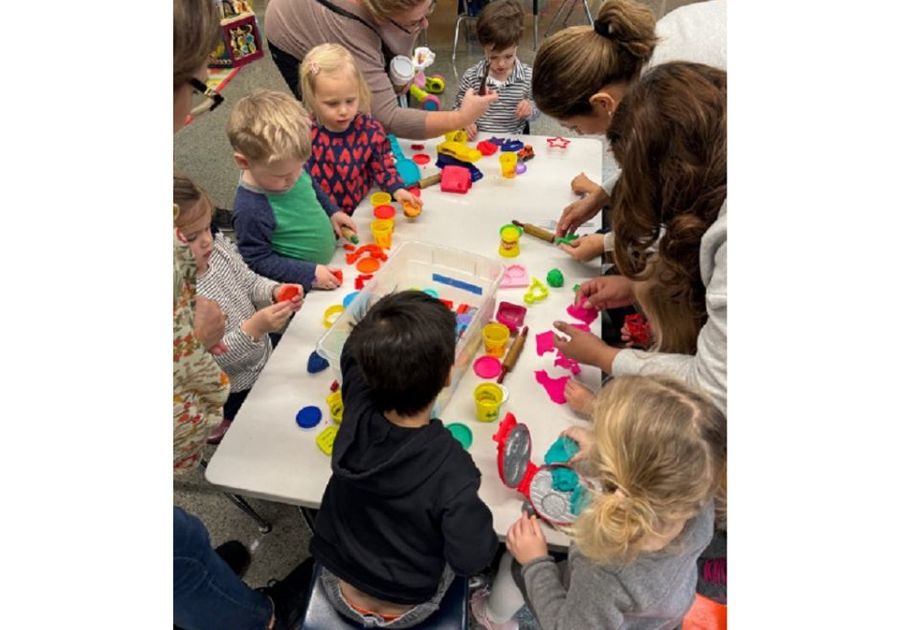 preschoolers at table playing with play doh