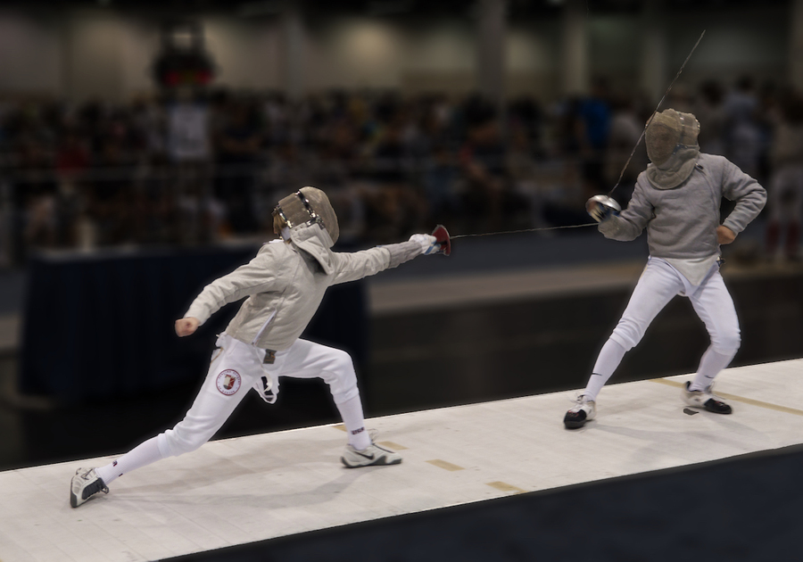 2 people fencing in a competition