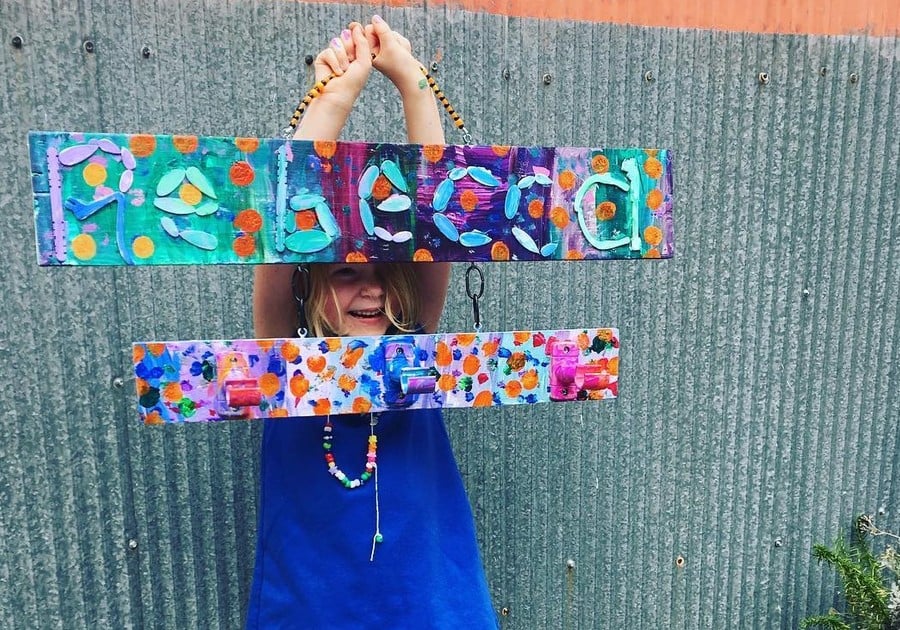 photo of young child holding up recycyled project