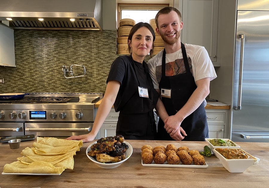 a couple in a kitchen with aprons