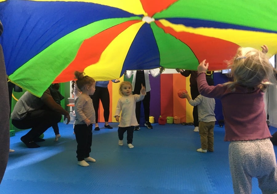 children doing parachute play at Kids Wonder