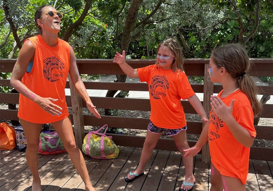 Camp counselor and campers playing on a beach boardwalk